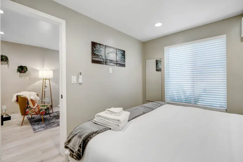 Bedroom with a window and an armchair in the next room