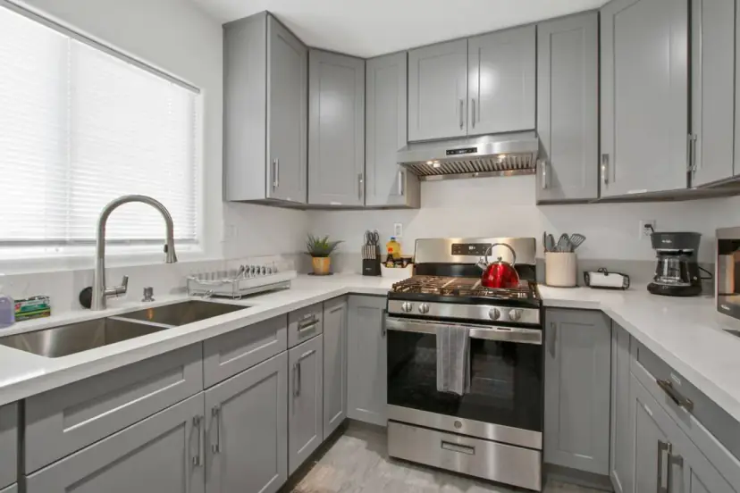 Grey shaker kitchen with a gas range and a double sink