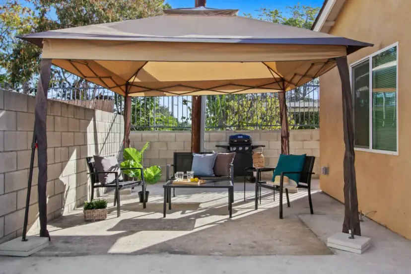 Gazebo patio with chairs, a coffee table and a grill