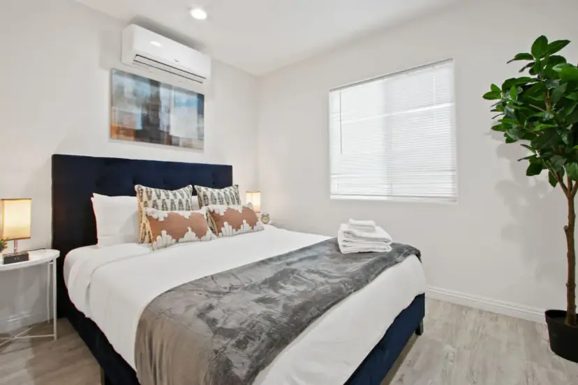 Bedroom with a navy headboard and a fiddle-leaf fig