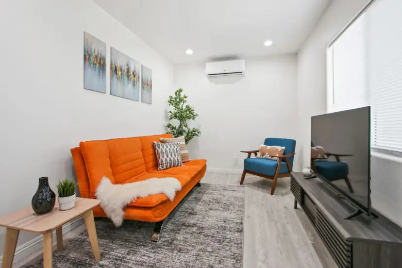 Living room with an orange futon sofa and a blue armchair
