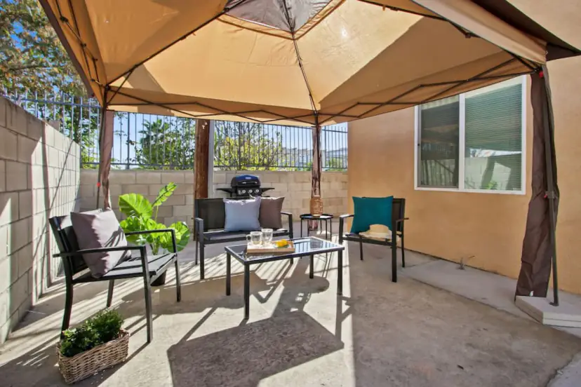 Gazebo patio with a grill against a block wall