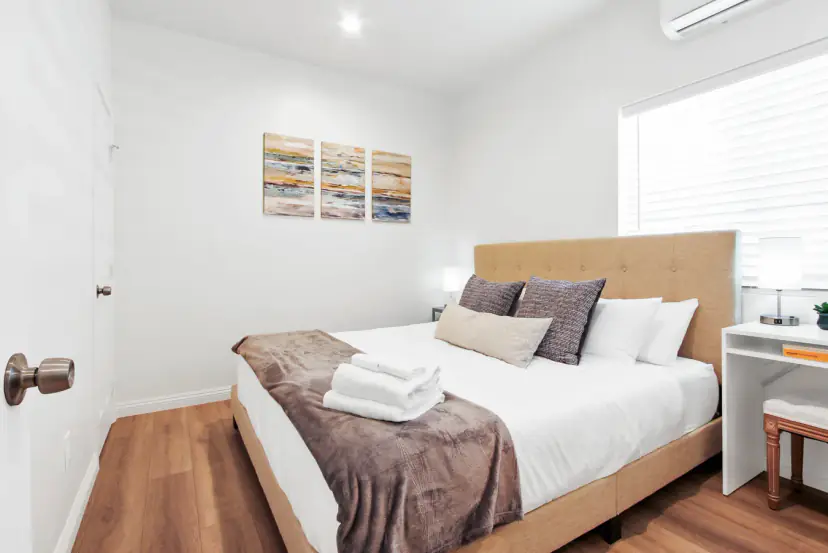 Bed with a tufted headboard and an abstract triptych