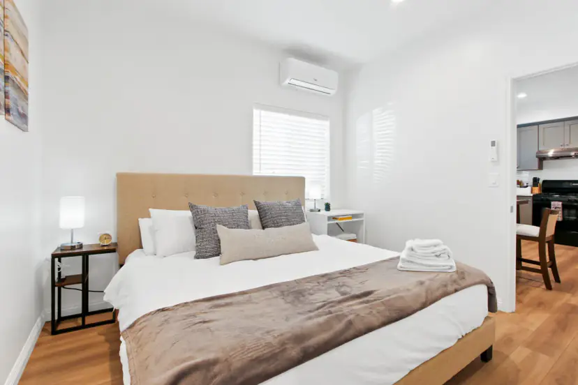 Bedroom with a wall AC and a view to the kitchen