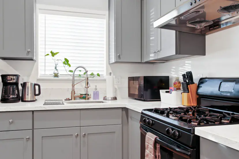 Kitchen sink under a window with a coffee maker
