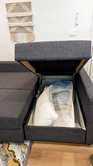 Storage sofa chaise opened to show extra bedding