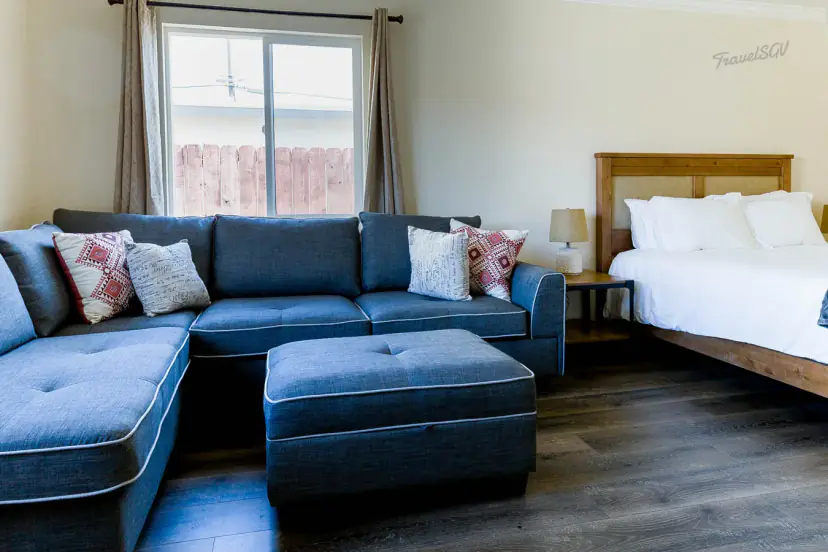 Living area with a blue-grey sectional and a bed