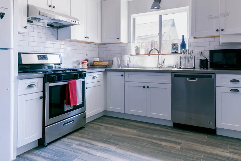 White shaker kitchen with a gas range and dishwasher