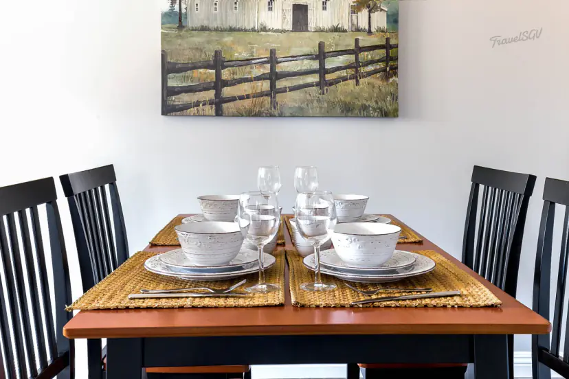 Dining table for four under a farm-scene painting