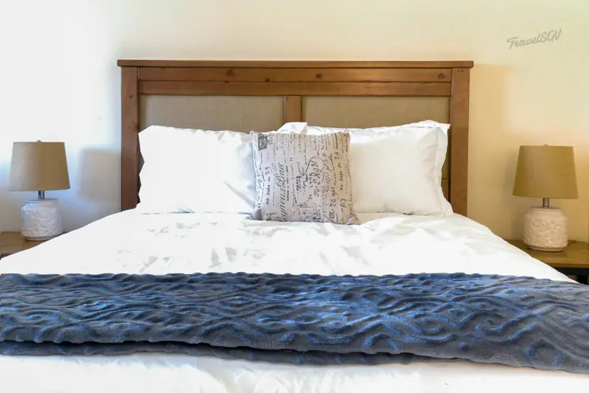 Bed with a wood headboard and a blue throw