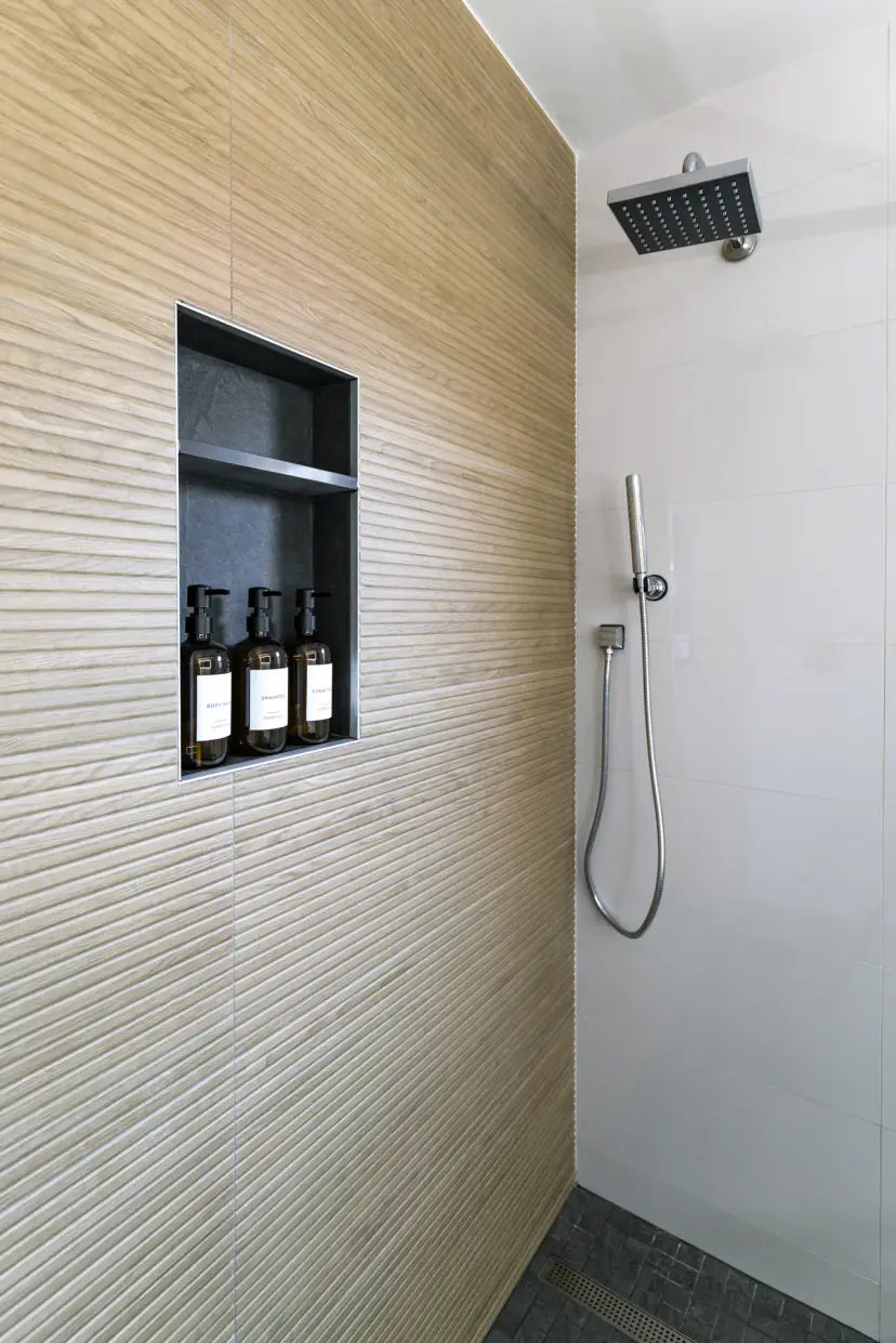 Walk-in shower with wood-look tile and a rain showerhead