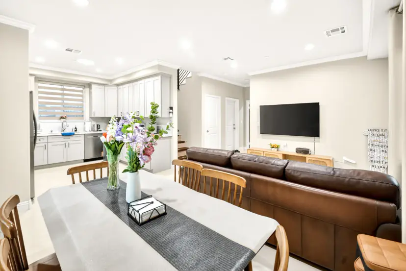 Dining table open to the living room and wall-mounted TV