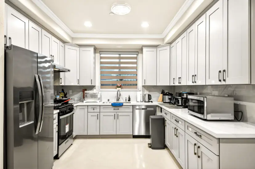 White shaker kitchen with a gas range and side-by-side fridge