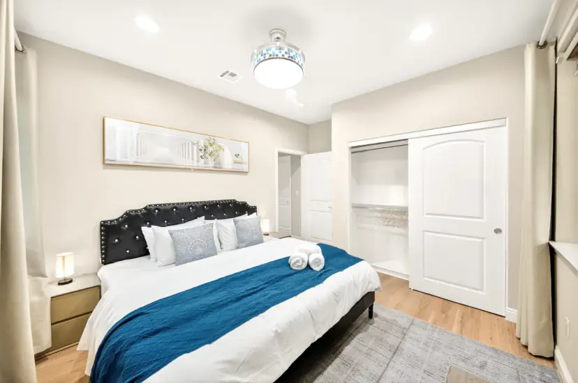 Bed with a black tufted headboard and sliding closet