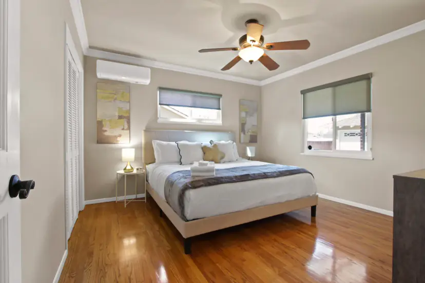 Bedroom with an upholstered bed and two windows