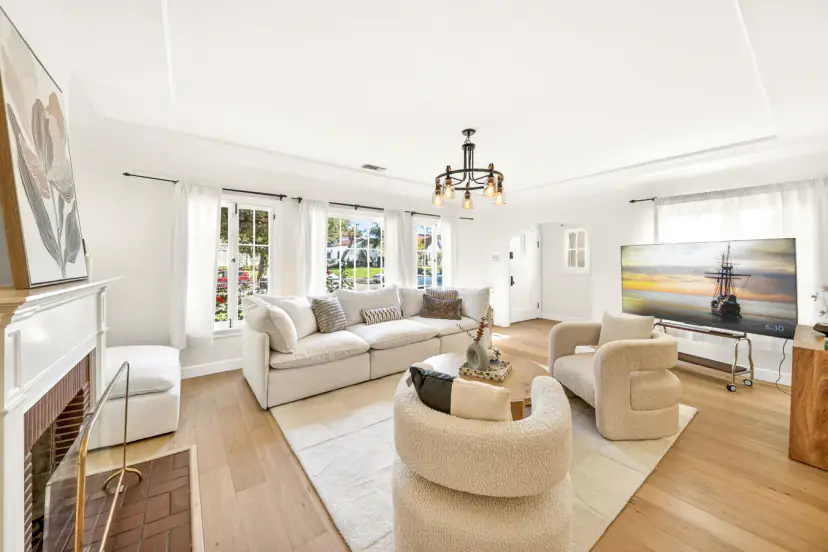 Living room with boucle chairs, a sectional and a brick fireplace