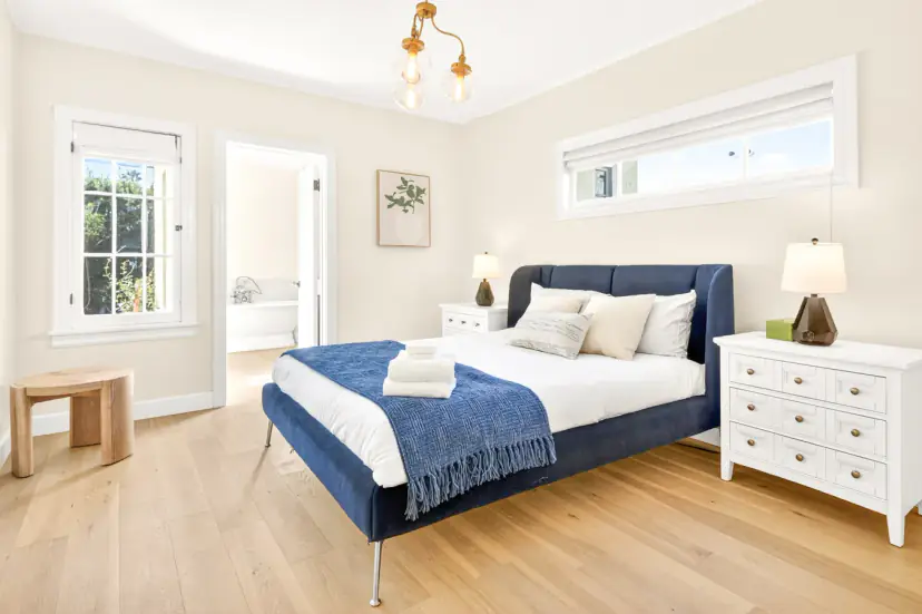 Bedroom with a navy velvet bed and a white dresser