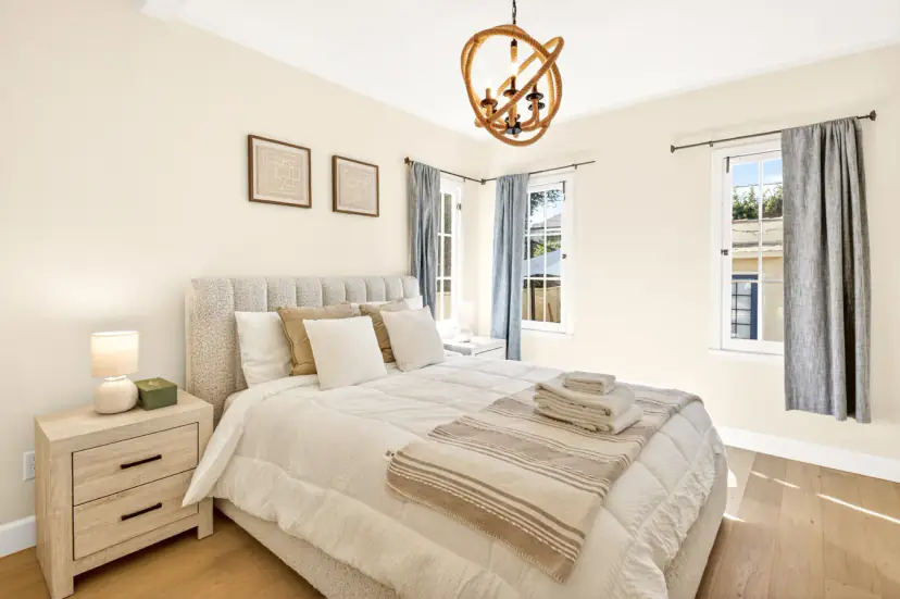 Bedroom with a channel-tufted bed and a rope chandelier