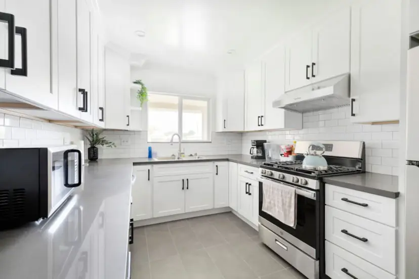 White kitchen with a gas range and subway tile
