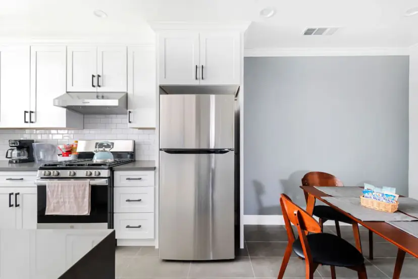 Kitchen with a stainless fridge and the dining table beyond