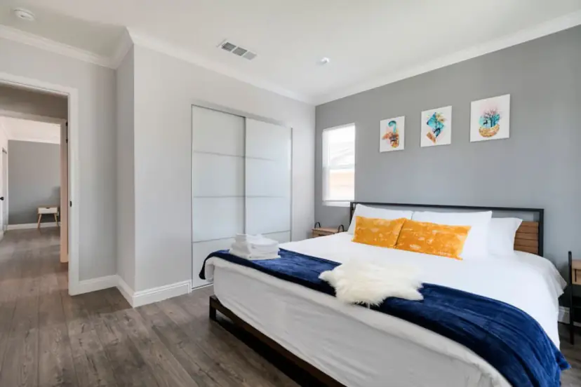 Bedroom with a king bed, orange pillows and a sliding closet