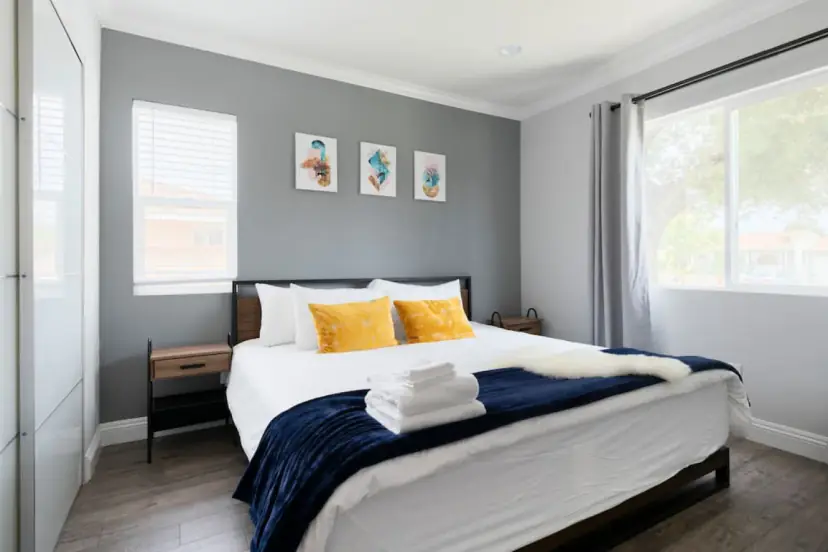 Bedroom with mustard pillows and a window