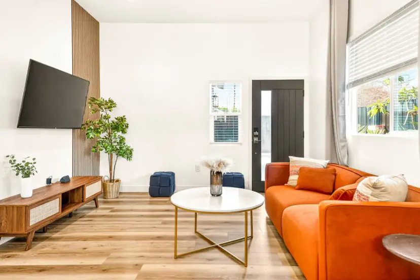 Bright living room with an orange sofa and a round coffee table