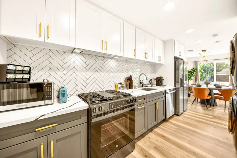 Kitchen with white upper cabinets and a herringbone backsplash