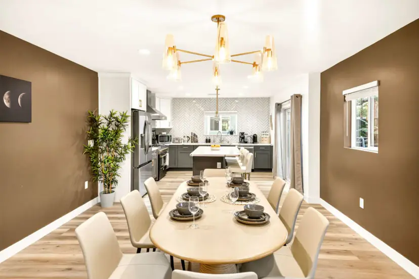 Long dining table set for a large group under a gold chandelier