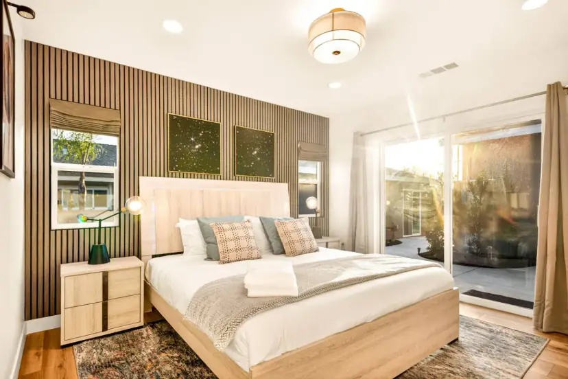Bedroom with a wood-slat wall, a bed and a sliding door to the patio