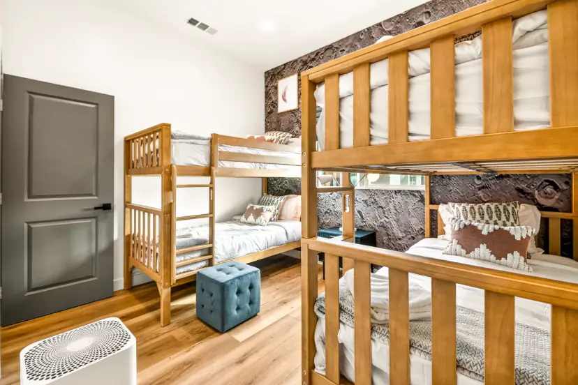 Bunk room with two sets of wooden bunk beds and a moon-surface accent wall
