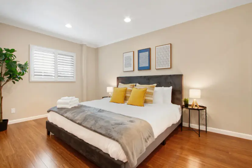 Bedroom with a queen bed and mustard pillows
