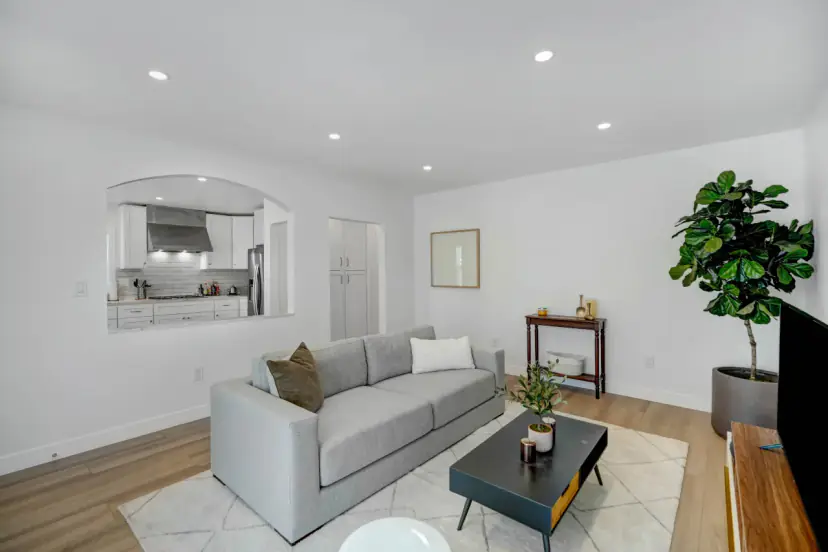 Living room with a grey sofa and a pass-through to the kitchen