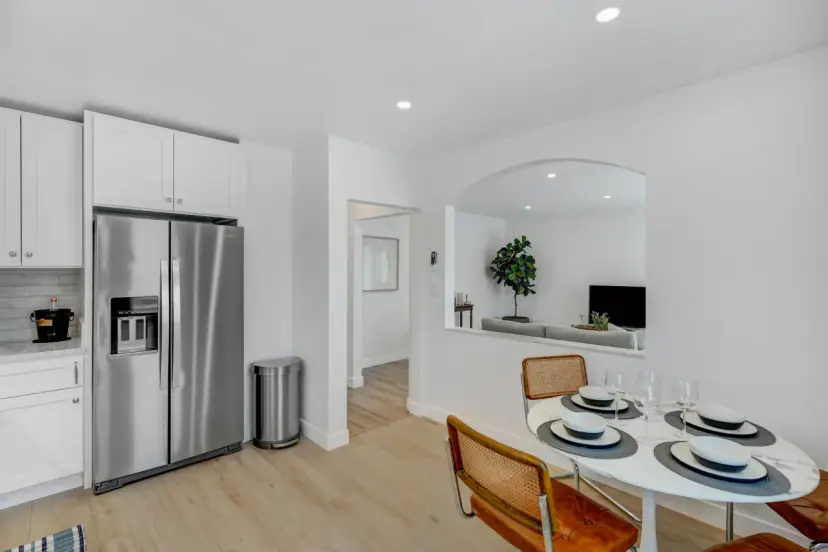 Dining nook with a round table and cane chairs beside the kitchen