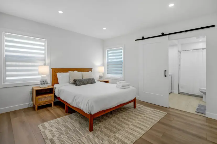 Bedroom with a wooden bed and a sliding barn door to the bathroom
