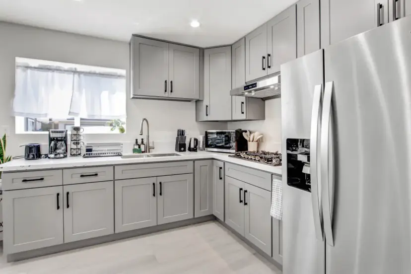 Grey shaker kitchen with a stainless fridge