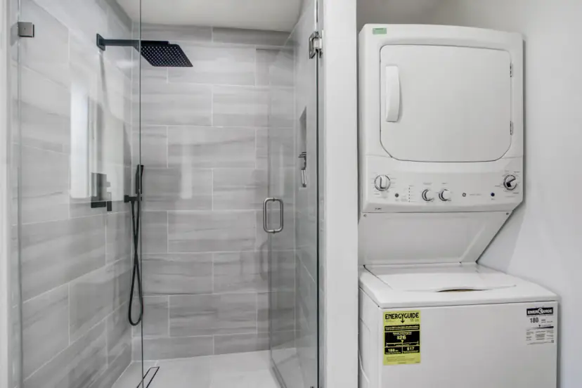 Glass shower and stacked washer and dryer