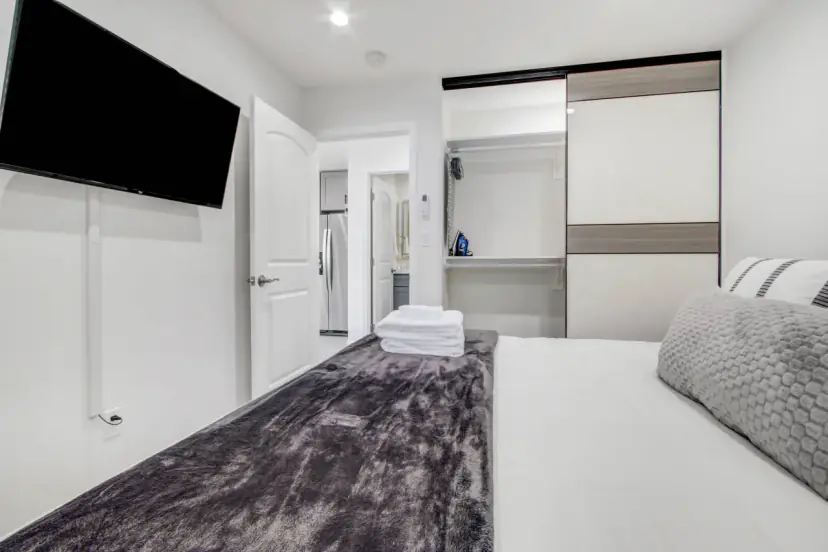 King bed with a wall TV and closet