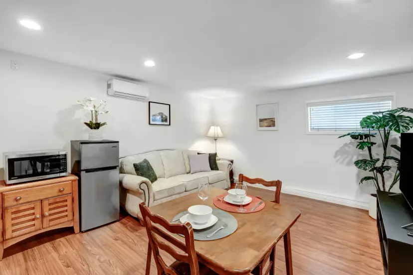 Sitting area with a floral sofa, a small dining table and a fridge