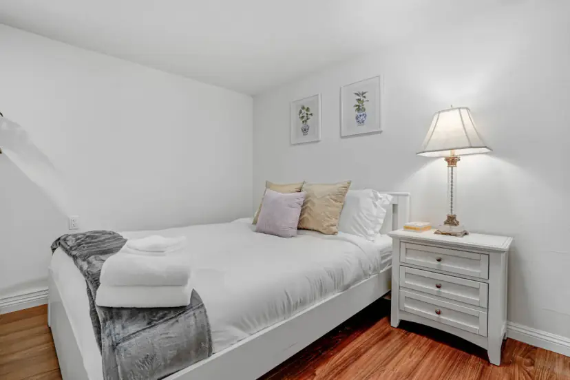 Bedroom with a queen bed and a nightstand lamp