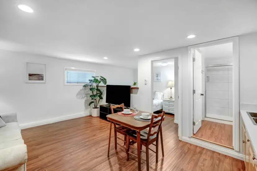 Living area with a dining table and doors to the bedroom and bath