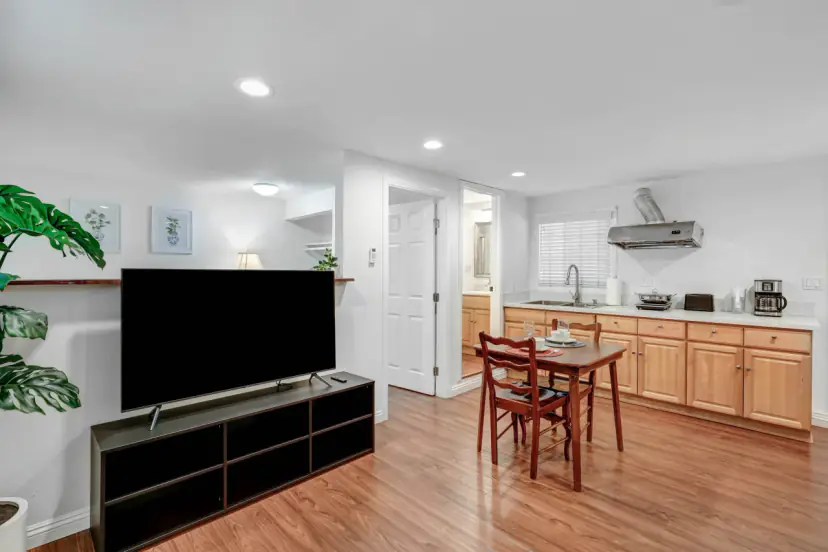 Living area with a TV console and the kitchen beyond