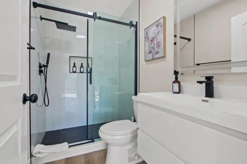 Bathroom with a black-framed glass shower and a white vanity