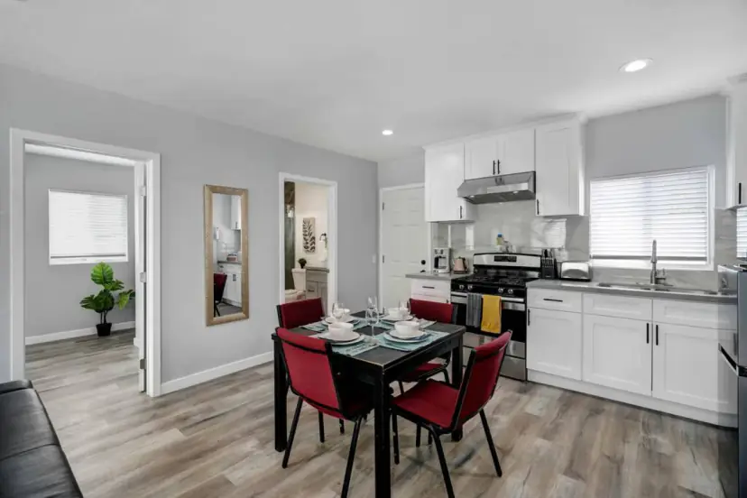 Dining table for four with red chairs by the kitchen