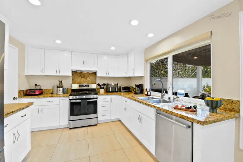 White kitchen with granite counters and a gas range