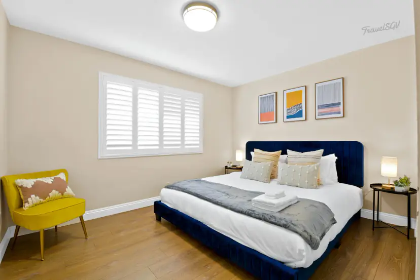 Bed with a navy velvet frame and a mustard chair