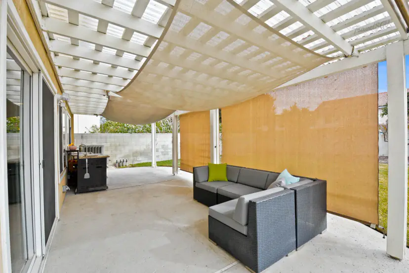 Covered patio with shade sails and a wicker sectional
