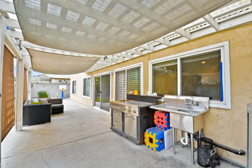 Covered patio with a grill station and steel sink