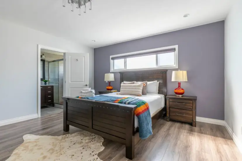 Bedroom with a dark wood bed and a lavender wall