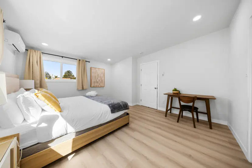 Sunny king bedroom with a desk